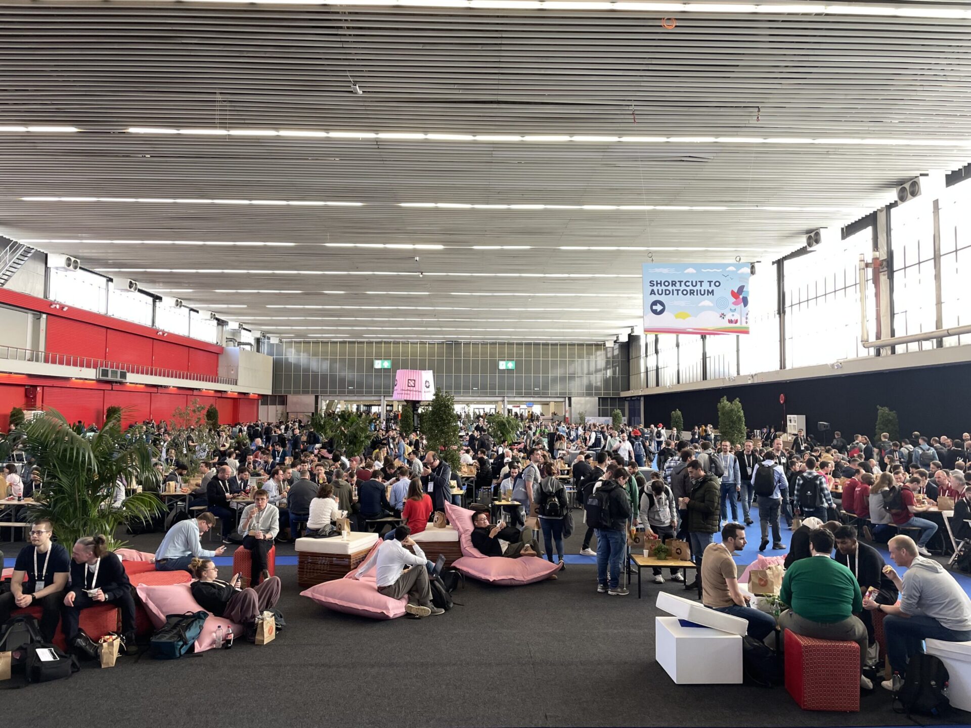 Attendees networking and discussing cloud-native topics at KubeCon + CloudNativeCon Europe 2023 in a large open space