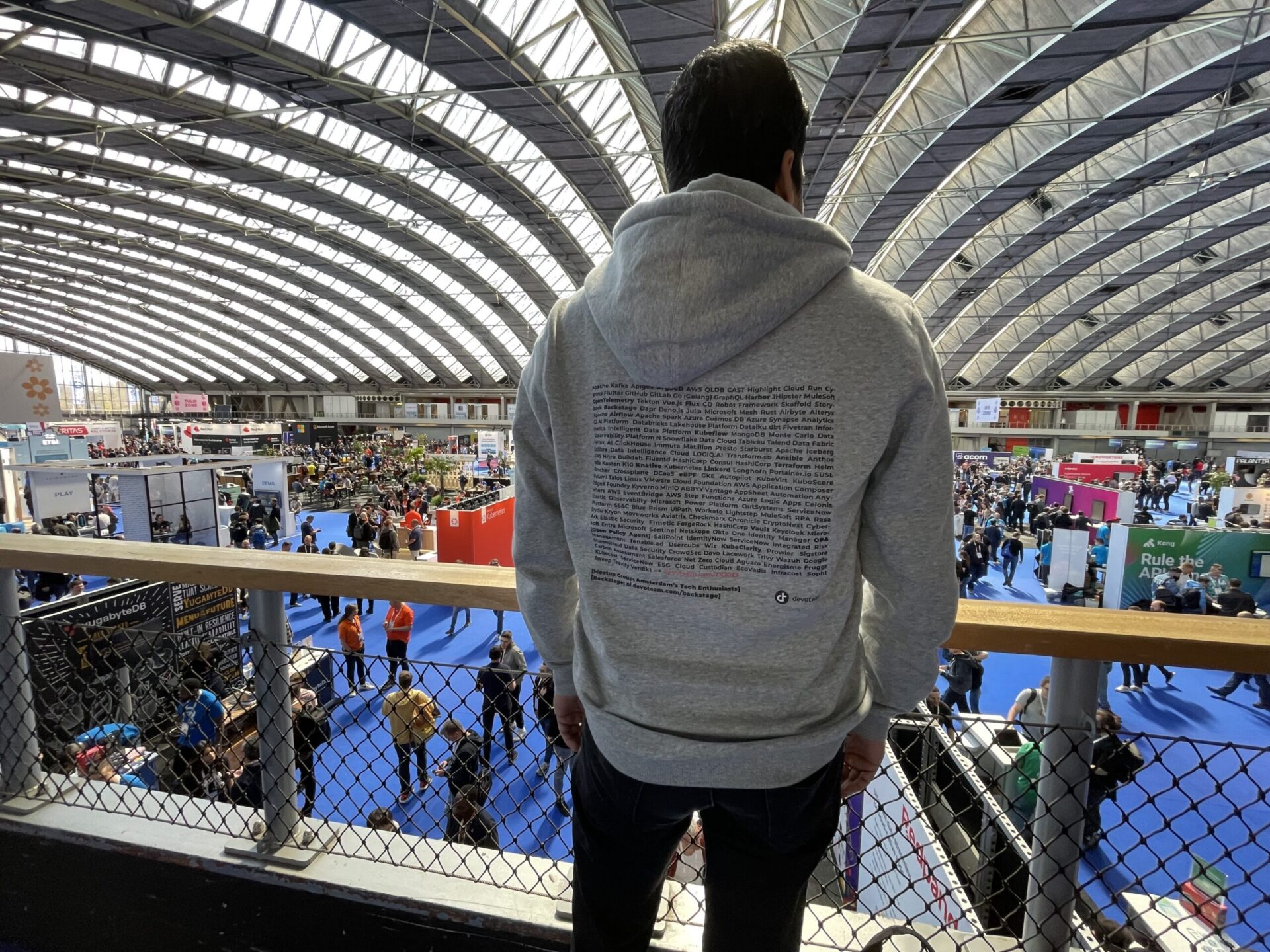 Participant overlooking the bustling event floor at KubeCon + CloudNativeCon Europe 2023.