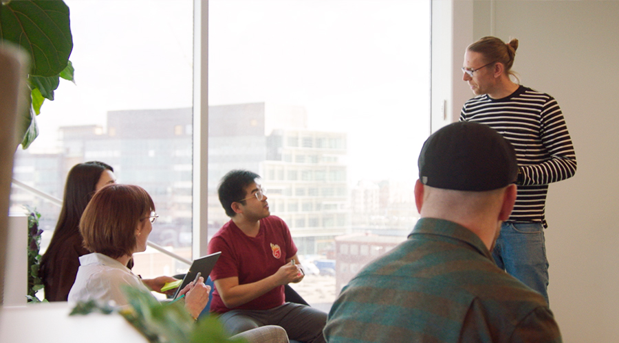 Product design team: a group of people chatting in an office space.