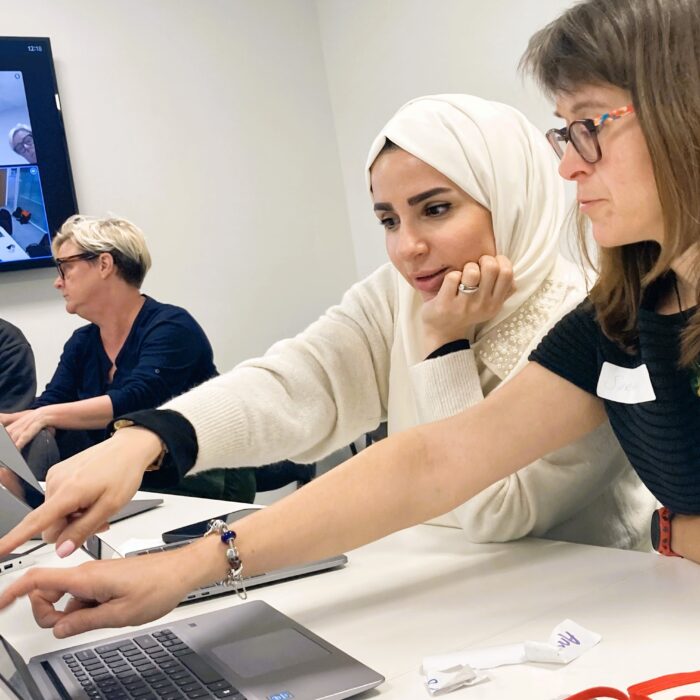 A diverse group of women working on laptops