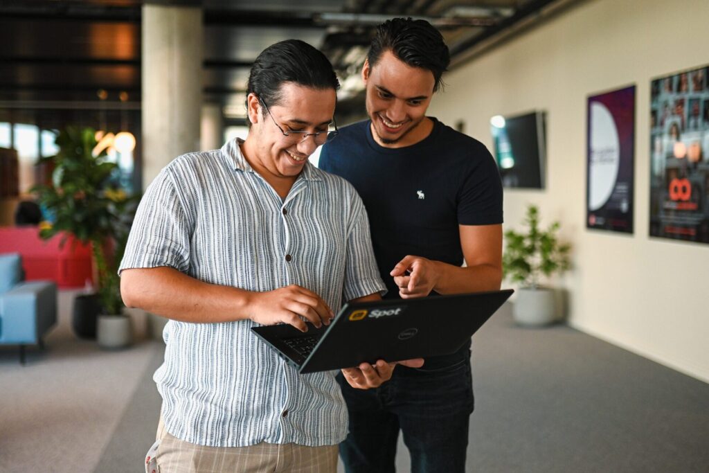 Two men looking a a laptop together