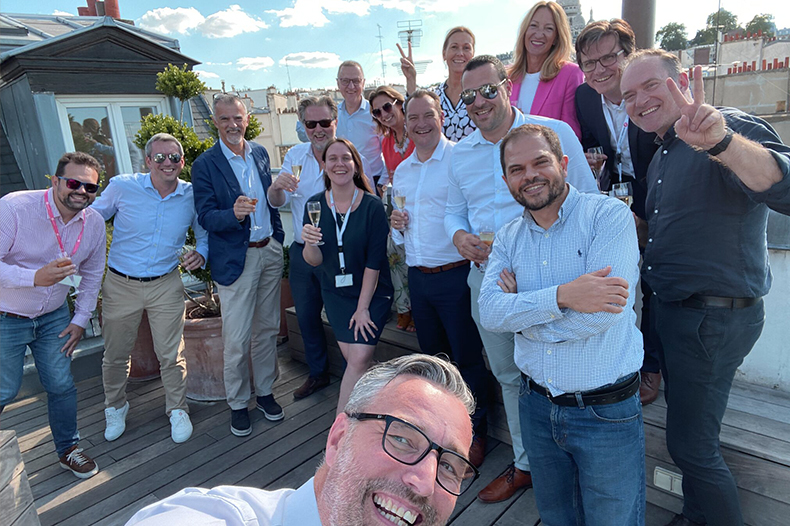 A cheerful group of friends poses together for a selfie on a sunny deck, capturing a fun moment together.