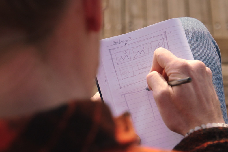 A person focused on writing notes on a piece of paper, showcasing creativity and concentration in their task.